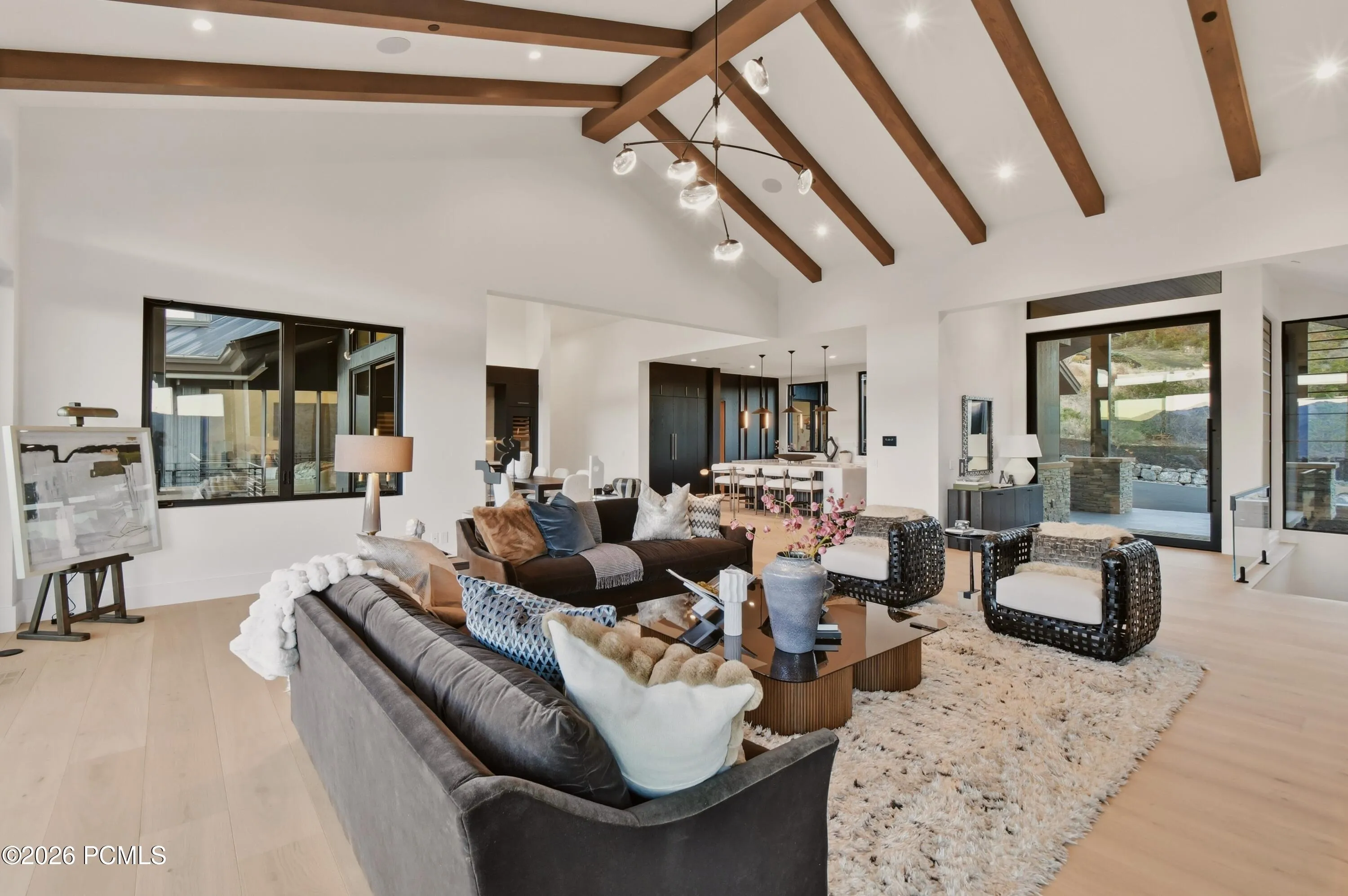 Soaring vaulted ceilings & richly textured wood beams define the grandly proportioned living room, blending impressive scale, natural warmth & refined mountain elegance.