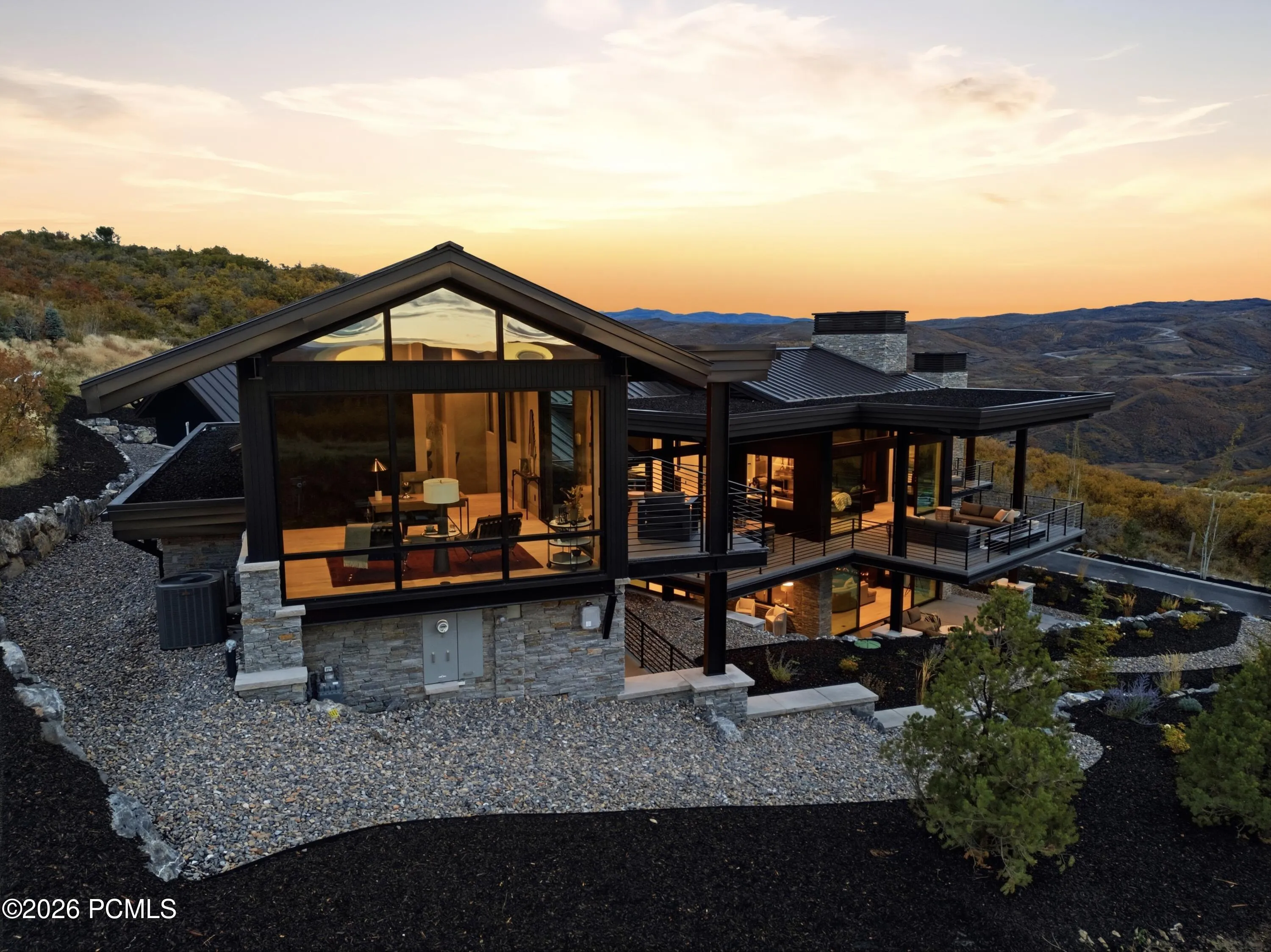 As twilight settles across the mountains, the home reveals an extraordinary evening presence. Expansive walls of glass radiate a rich, inviting warmth, illuminating the architectural lines & creating a captivating contrast against the rugged natural landscape. The interplay of glowing interiors, refined exterior finishes & dramatic mountain silhouettes gives the home the presence of a curated work of art, establishing an unforgettable sense of arrival long after sunset.