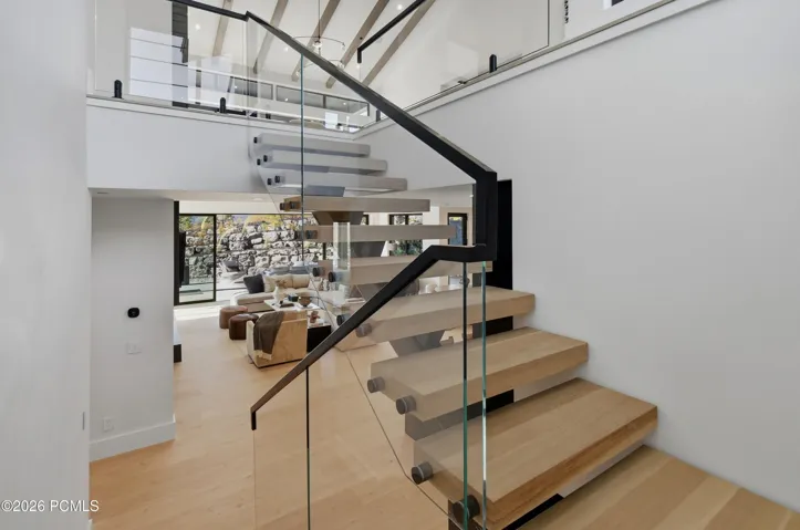 An extraordinary floating staircase enclosed in glass creates a breathtaking architectural statement, transforming the journey to the lower level into an experience of elevated design. An artful interplay of transparency, light & architectural precision lends the space a captivating sense of movement, where even the transition between floors becomes a defining expression of the home’s distinctive character.