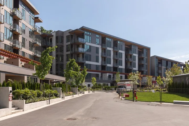 Contemporary building exteriors featuring varied facade materials including wood-finish panels and grey siding