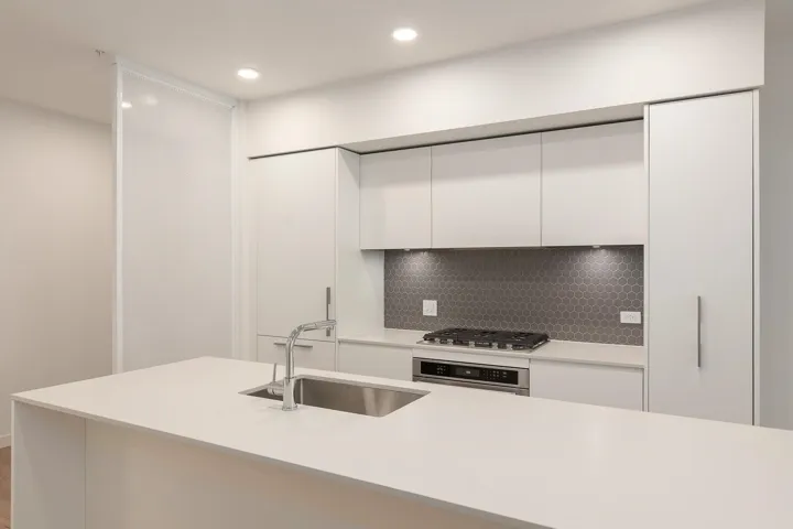 Kitchen island featuring a stainless steel sink with a high-arc faucet, integrated gas cooktop, and built-in microwave