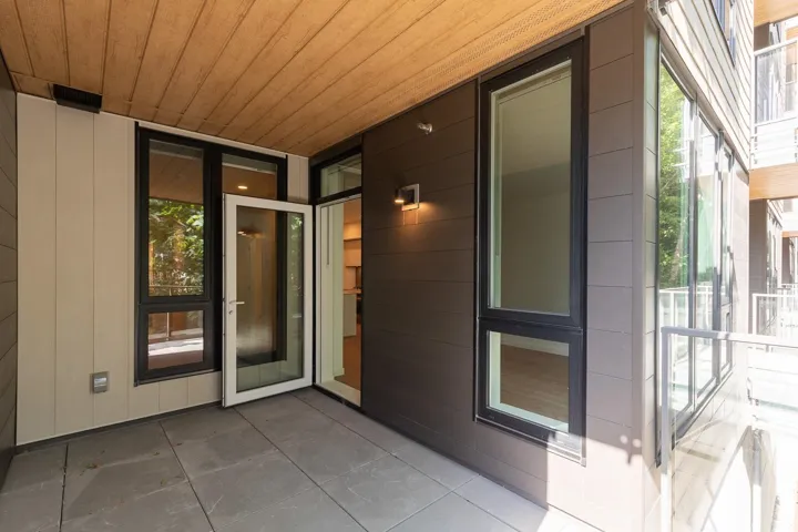 Private patio featuring large format tile flooring, a wood-finish ceiling, and modern wall sconces