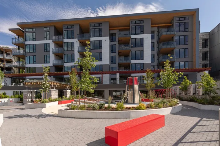 Modern multi-story building featuring expansive glass balconies and wood soffit accents