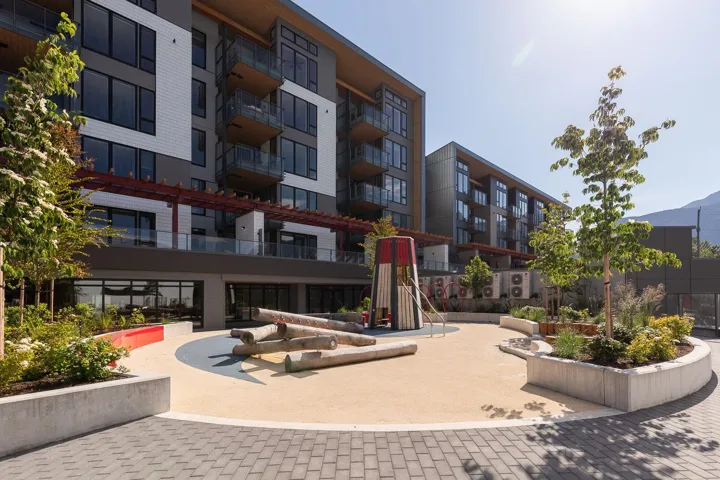 Contemporary building exterior featuring a neutral color palette, expansive window lines, and multiple balconies with glass railings