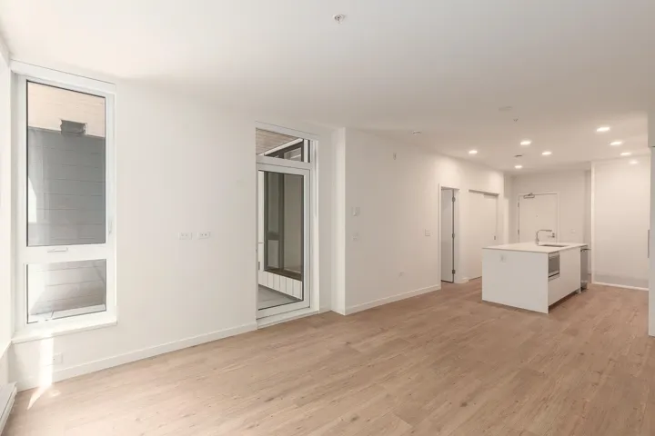 Open-concept living space with light wood-finish flooring