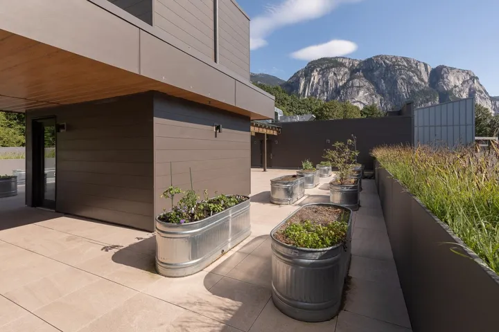 Rooftop patio featuring expansive mountain scenery, contemporary building materials, and multiple planters