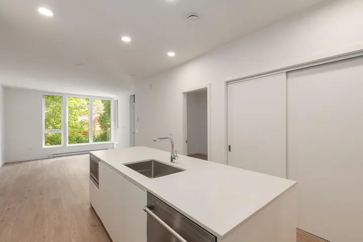 Contemporary kitchen island featuring an undermount stainless steel sink and integrated appliances