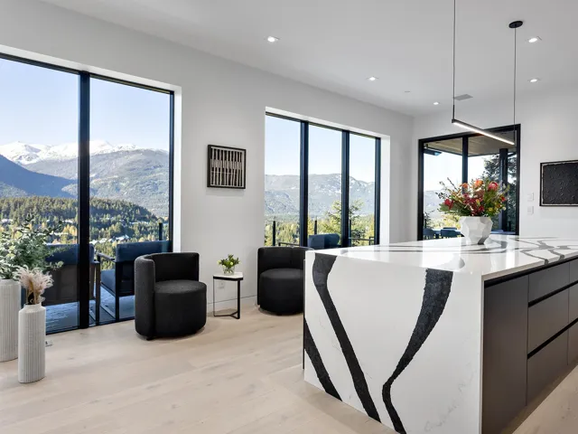 Kitchen with a mountain view, light wood finished floors, decorative light fixtures, light stone counters, and recessed lighting