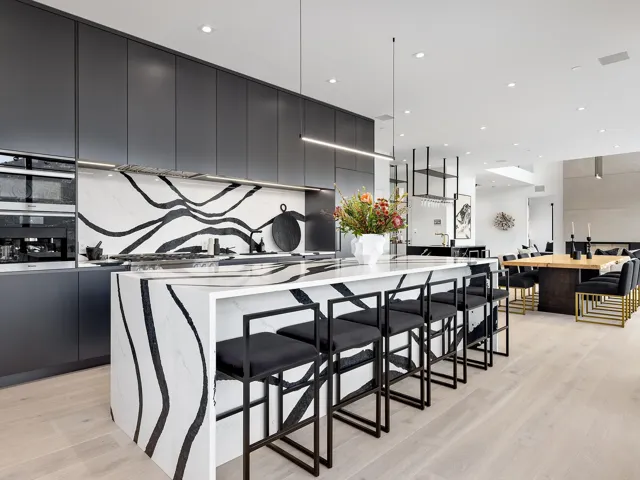 Kitchen featuring a breakfast bar, modern cabinets, light wood-style flooring, dark cabinetry, and recessed lighting
