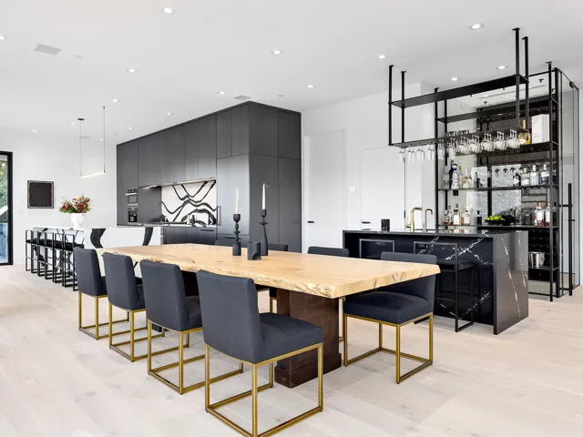 Dining room with light wood-type flooring, bar with sink, and recessed lighting