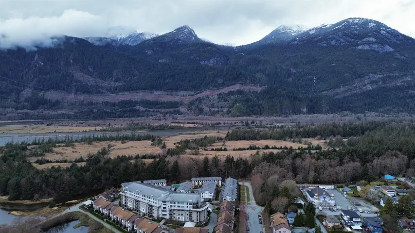 Birds eye view of property with a wooded view and a mountain view