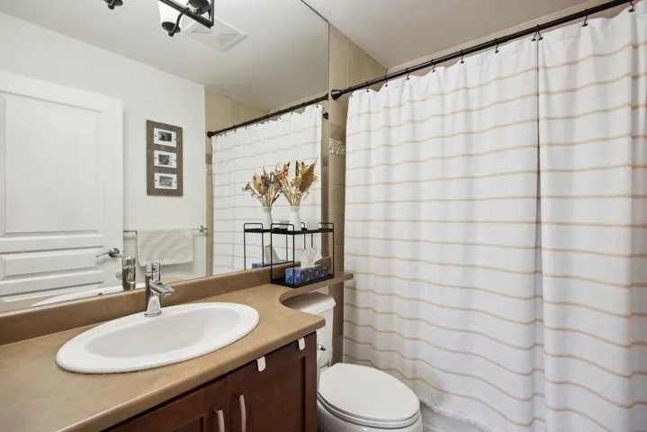 Full bath with a shower with shower curtain, toilet, and vanity