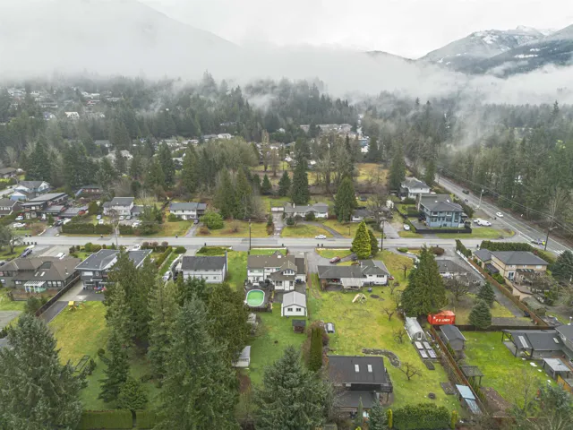 Aerial view of property and surrounding area with nearby suburban area and a mountain backdrop