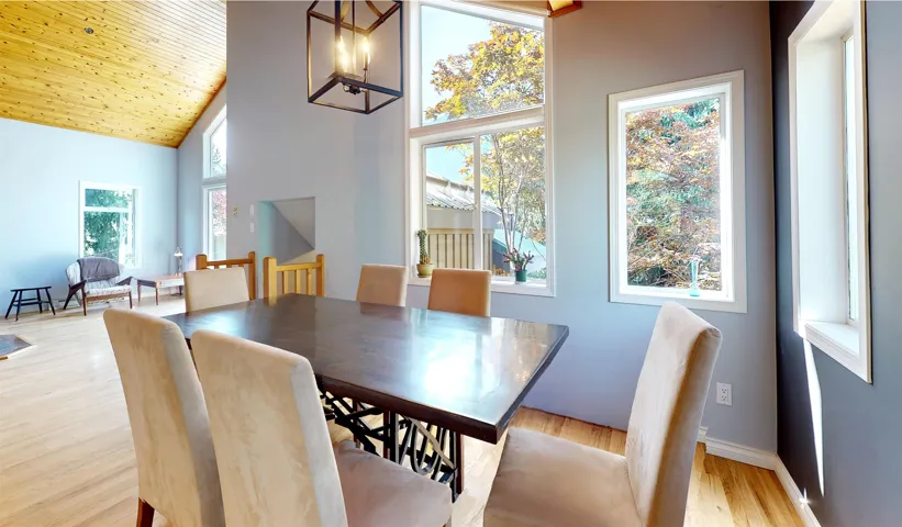 Dining space featuring plenty of natural light, high vaulted ceiling, and light wood finished floors