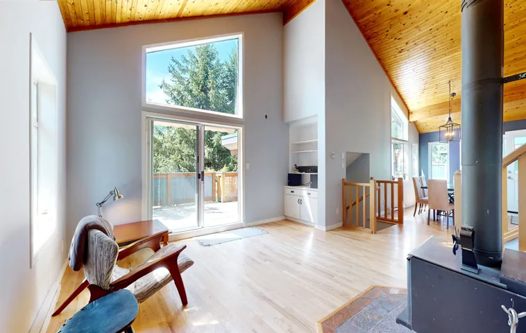 Living room featuring wood ceiling, wood finished floors, and a high ceiling