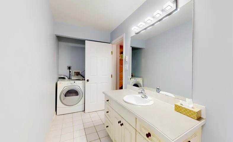 Bathroom featuring washer / clothes dryer, tile patterned flooring, and vanity