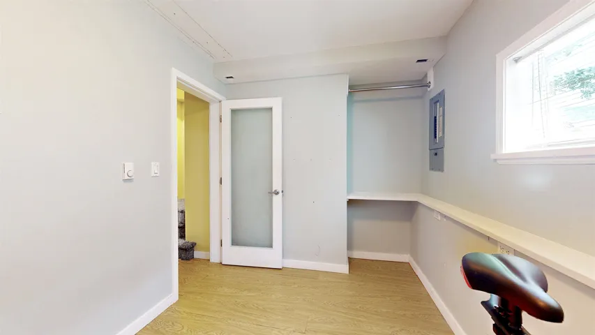 Unfurnished office featuring light wood-style flooring and baseboards