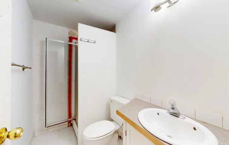 Full bath with a shower stall, vanity, and tile patterned flooring