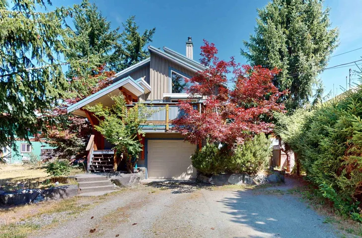 View of front of property with stairway, driveway, a garage, and board and batten siding
