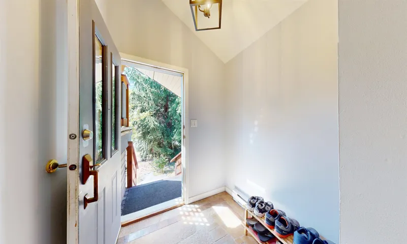 Entryway with lofted ceiling and baseboards