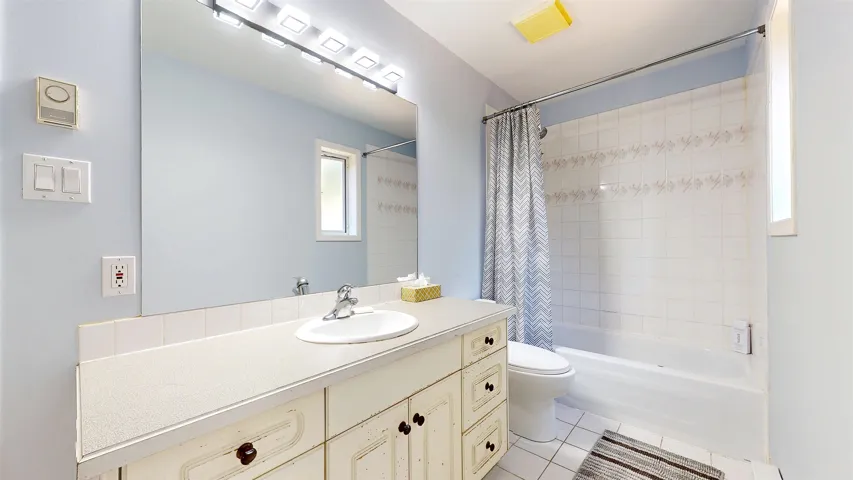 Bathroom with vanity, tile patterned flooring, and shower / tub combo with curtain
