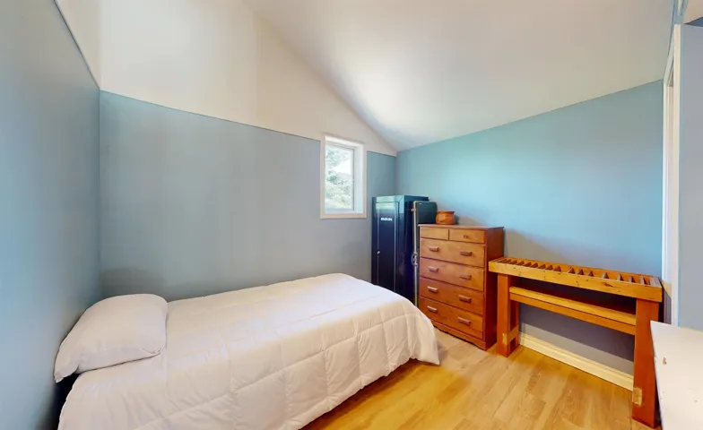 Bedroom with vaulted ceiling and light wood-style floors