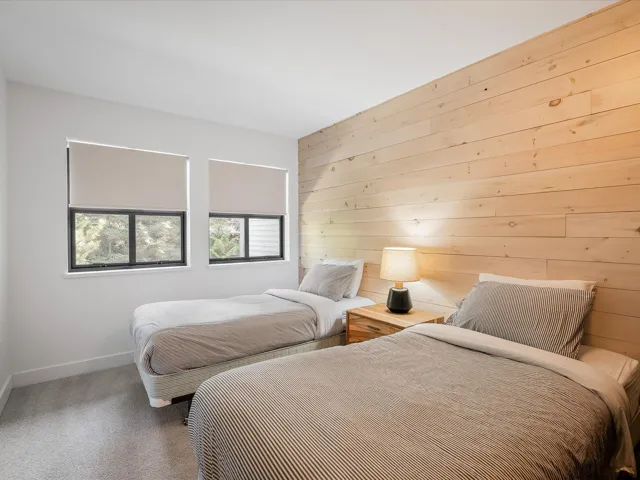 Carpeted bedroom with wood walls and baseboards