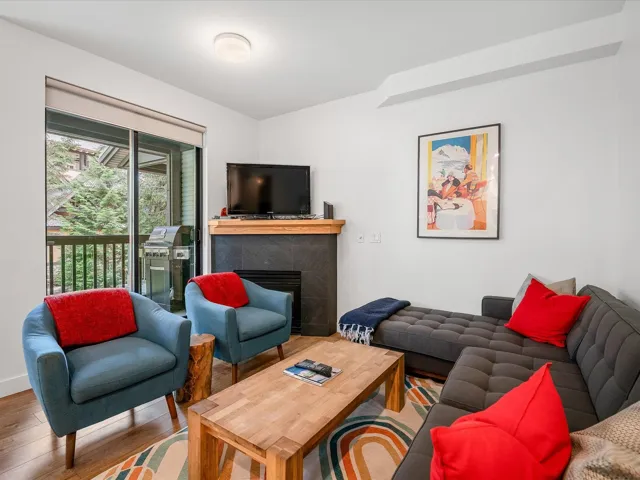 Living room featuring baseboards, wood finished floors, and a fireplace