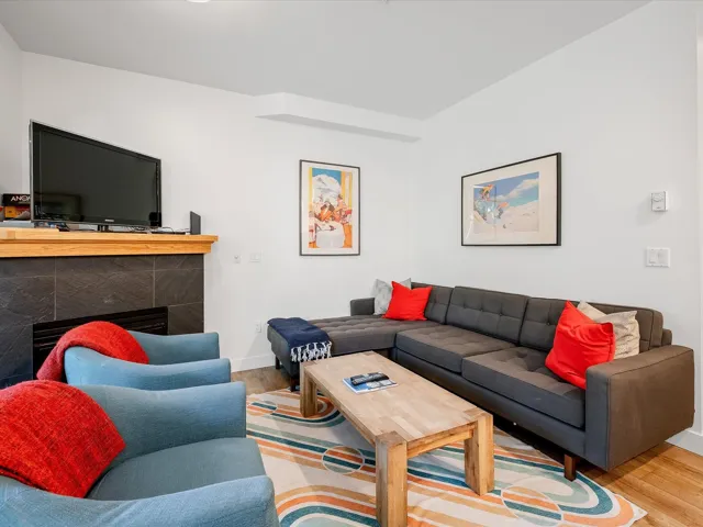 Living area with a tile fireplace, wood finished floors, and baseboards