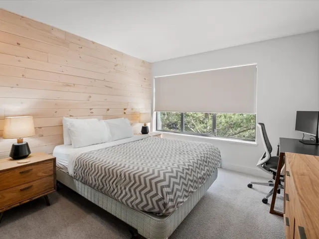 Bedroom with wooden walls and carpet flooring