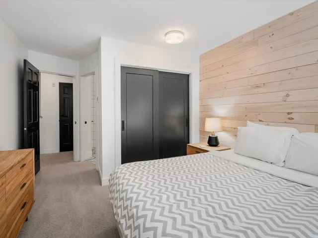 Bedroom featuring a closet, wood walls, and carpet floors
