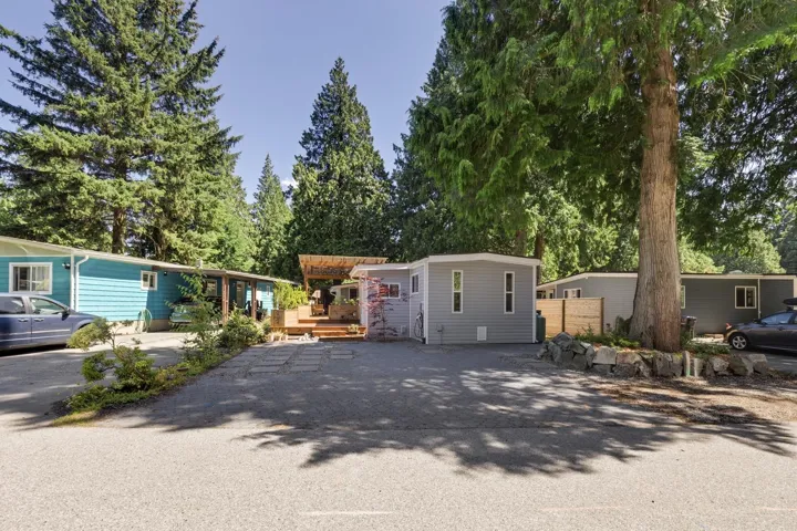 Manufactured / mobile home with a deck, an outdoor structure, and driveway