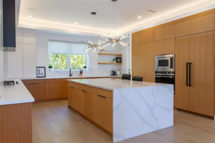 Kitchen featuring modern cabinets, appliances with stainless steel finishes, open shelves, light stone countertops, and recessed lighting