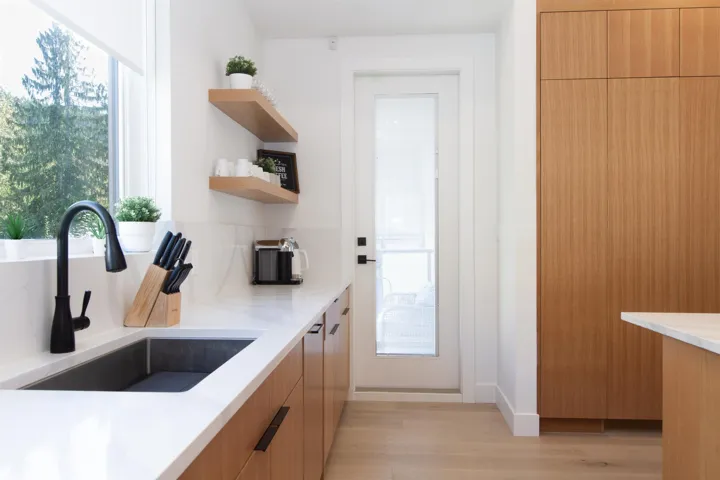 Kitchen featuring a sink, modern cabinets, light wood-style flooring, and open shelves