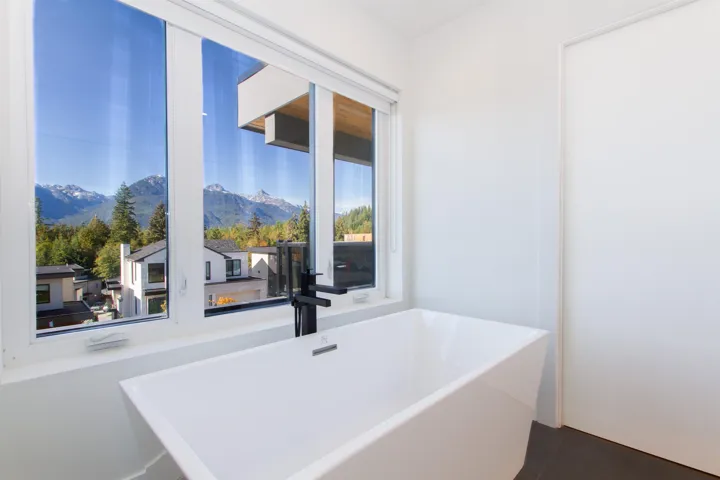 Full bathroom with a mountain view, healthy amount of natural light, a freestanding tub, and tile patterned floors