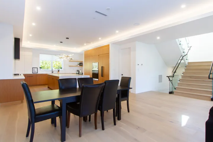 Dining space featuring a chandelier, light wood-type flooring, recessed lighting, stairway, and a tray ceiling