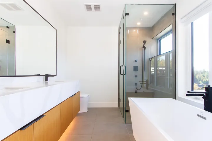 Full bath with a stall shower, a freestanding tub, tile patterned floors, baseboards, and vanity