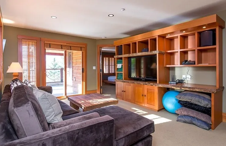 Living area with light colored carpet and recessed lighting