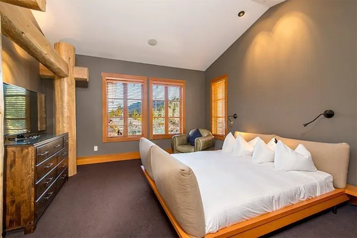 Bedroom featuring dark colored carpet and vaulted ceiling