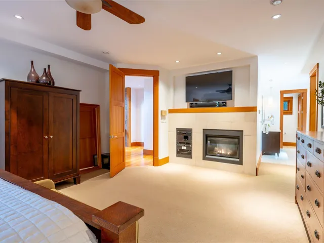 Bedroom with recessed lighting, light carpet, a tiled fireplace, and a ceiling fan