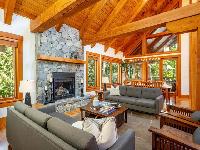 Living area featuring hardwood / wood-style floors, a wooden ceiling with exposed beams, high vaulted ceiling, a fireplace, and healthy amount of natural light