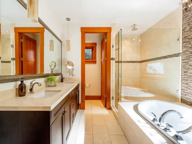 Full bath with a stall shower, a bath, double vanity, and light tile patterned floors