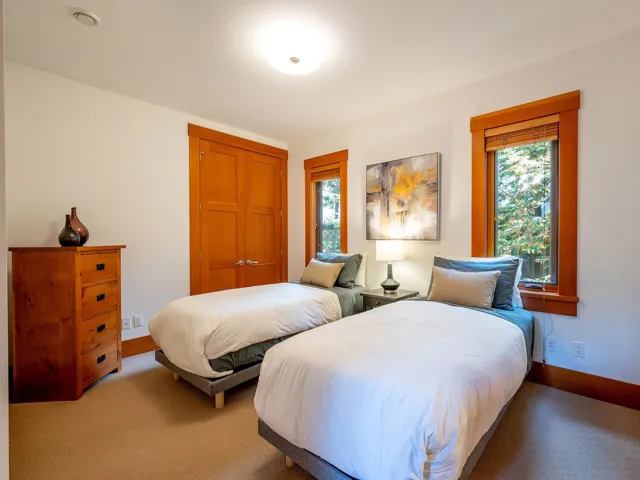 Carpeted bedroom featuring multiple windows and a closet