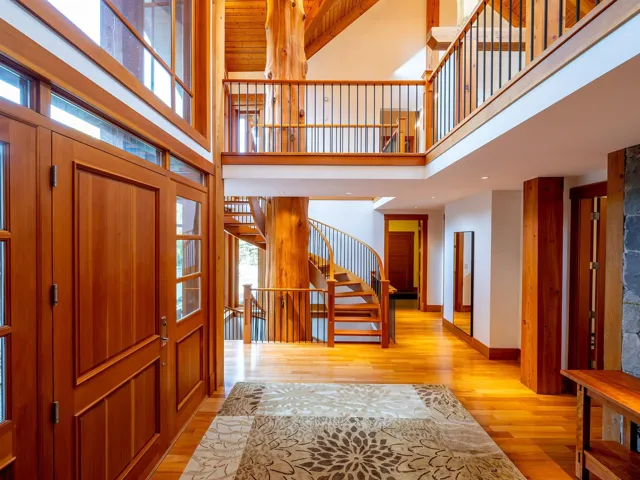 Entryway with light wood-style flooring, stairway, and a high ceiling