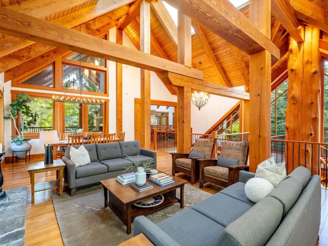 Living area featuring high vaulted ceiling, wood finished floors, a chandelier, and a wooden ceiling with exposed beams
