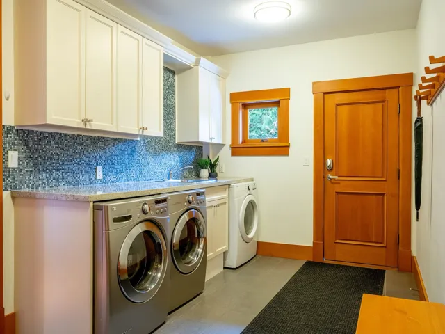 Laundry area with cabinet space, washing machine and clothes dryer, and light tile patterned floors