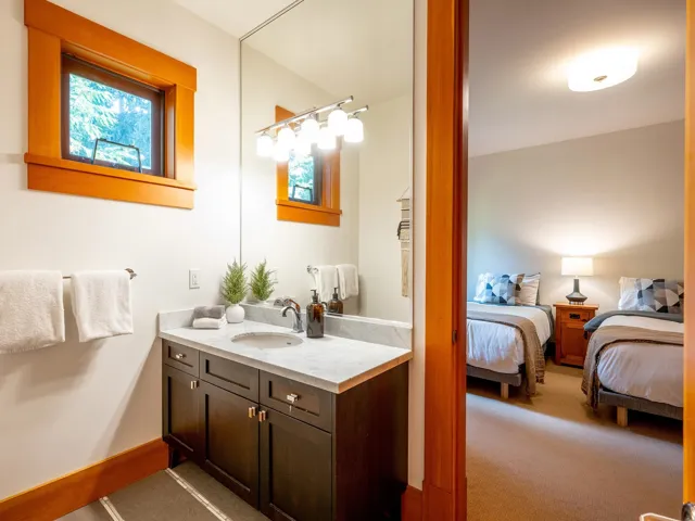 Ensuite bathroom with vanity and light carpet