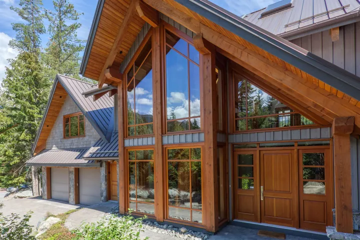 View of side of home featuring a standing seam roof, a metal roof, a garage, and board and batten siding