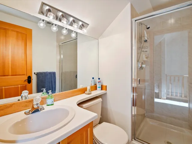Bathroom with a shower stall, vanity, and toilet