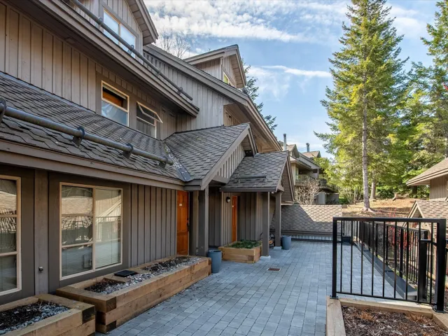 View of property exterior with board and batten siding, a shingled roof, and a patio